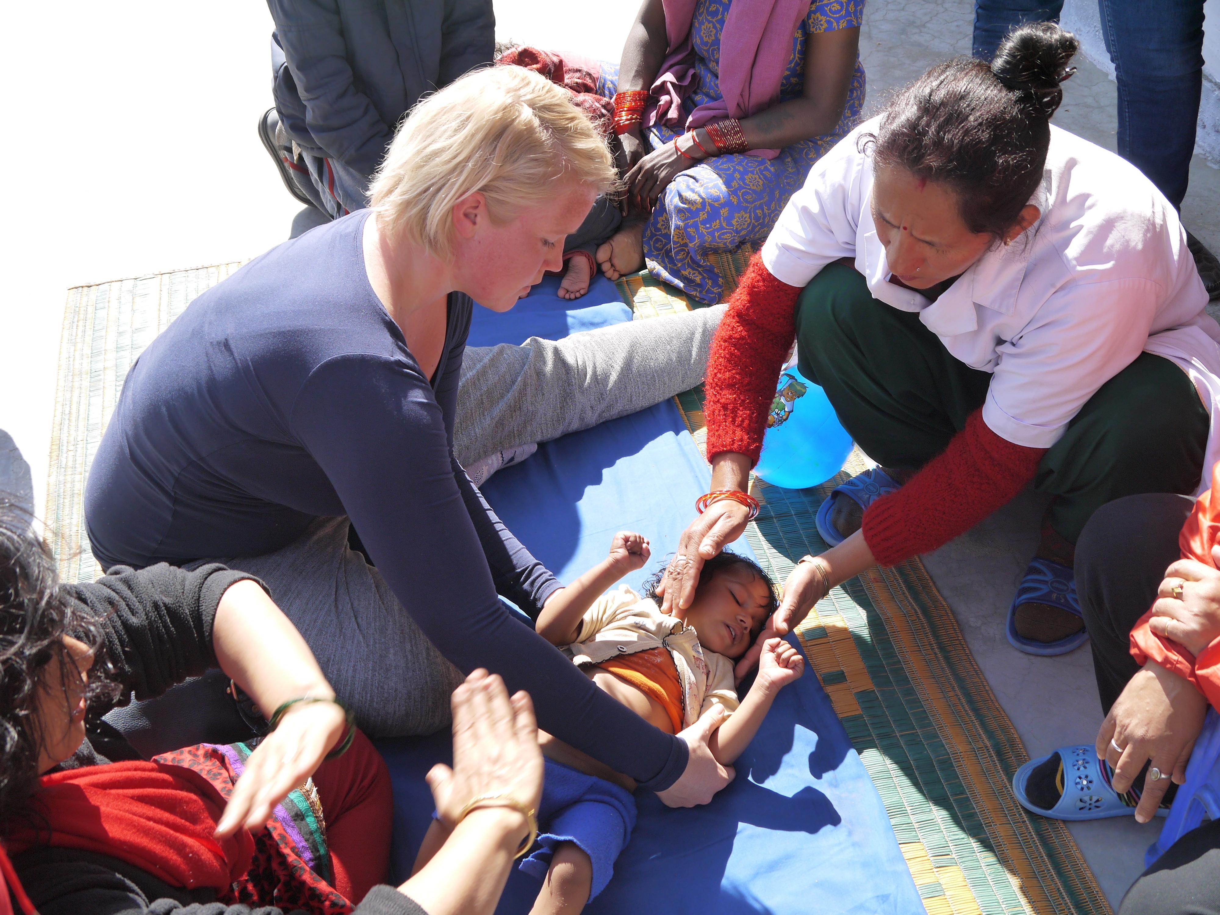 Sesión de fisioterapia de una niña pequeña con dos de nuestras internas en Nepal. Internas de Fisioterapia ayudan a una niña durante sus ejercicios.